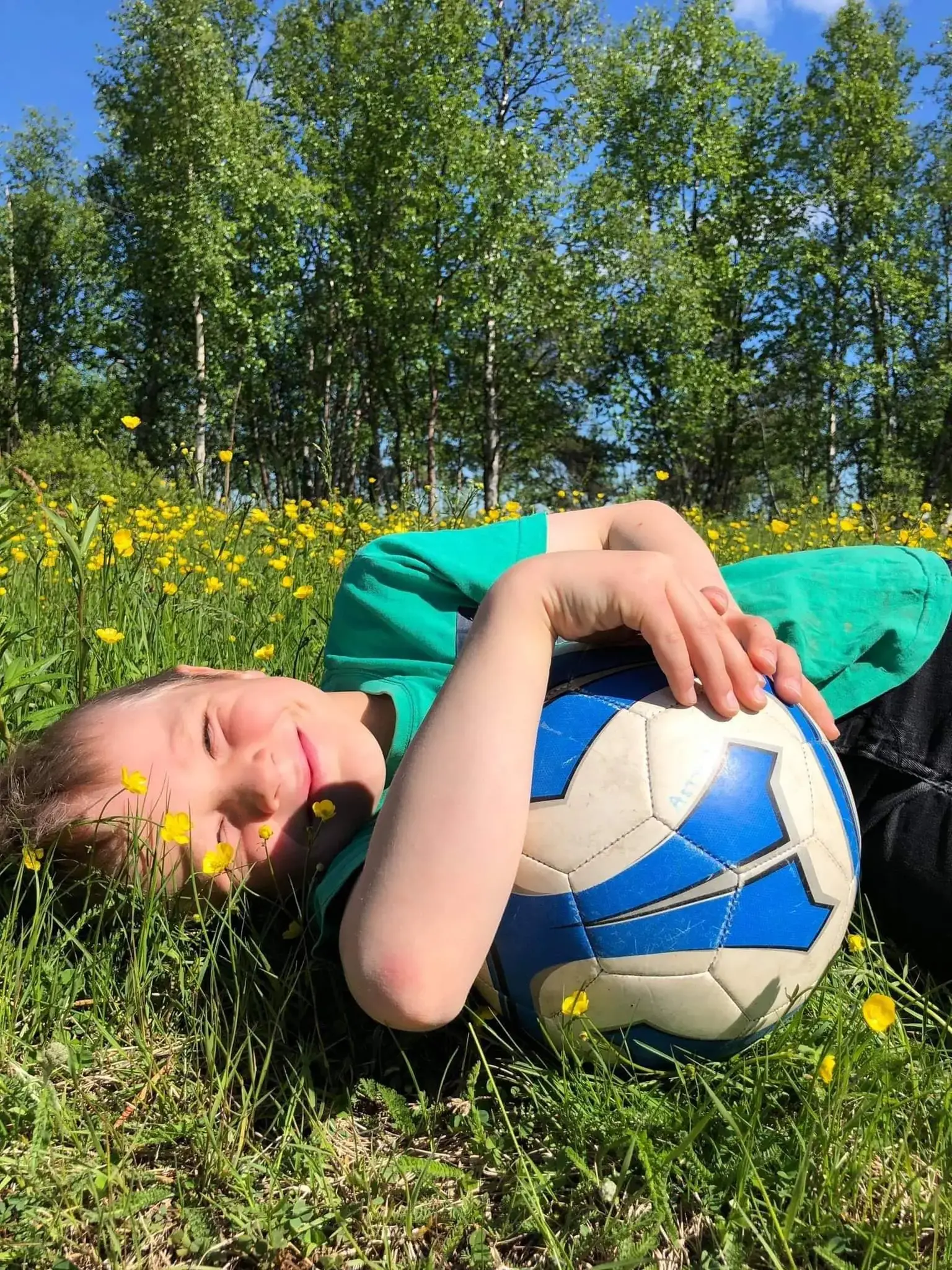 barn med fotboll i gräset